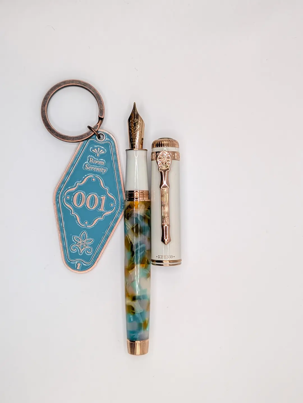 Dominant Industry Keyno fountain pen No. 001 Serenity, uncapped, next to its room-key-style keychain|300